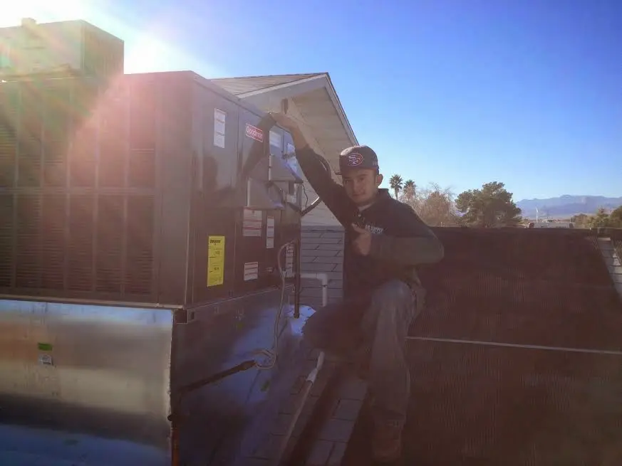 HVAC technician performing Air Duct Cleaning on a rooftop unit in Montgomery Village